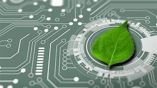 A fresh green leaf placed on an electronic circuit board with glowing lines, representing the integration of nature and technology or sustainable tech.